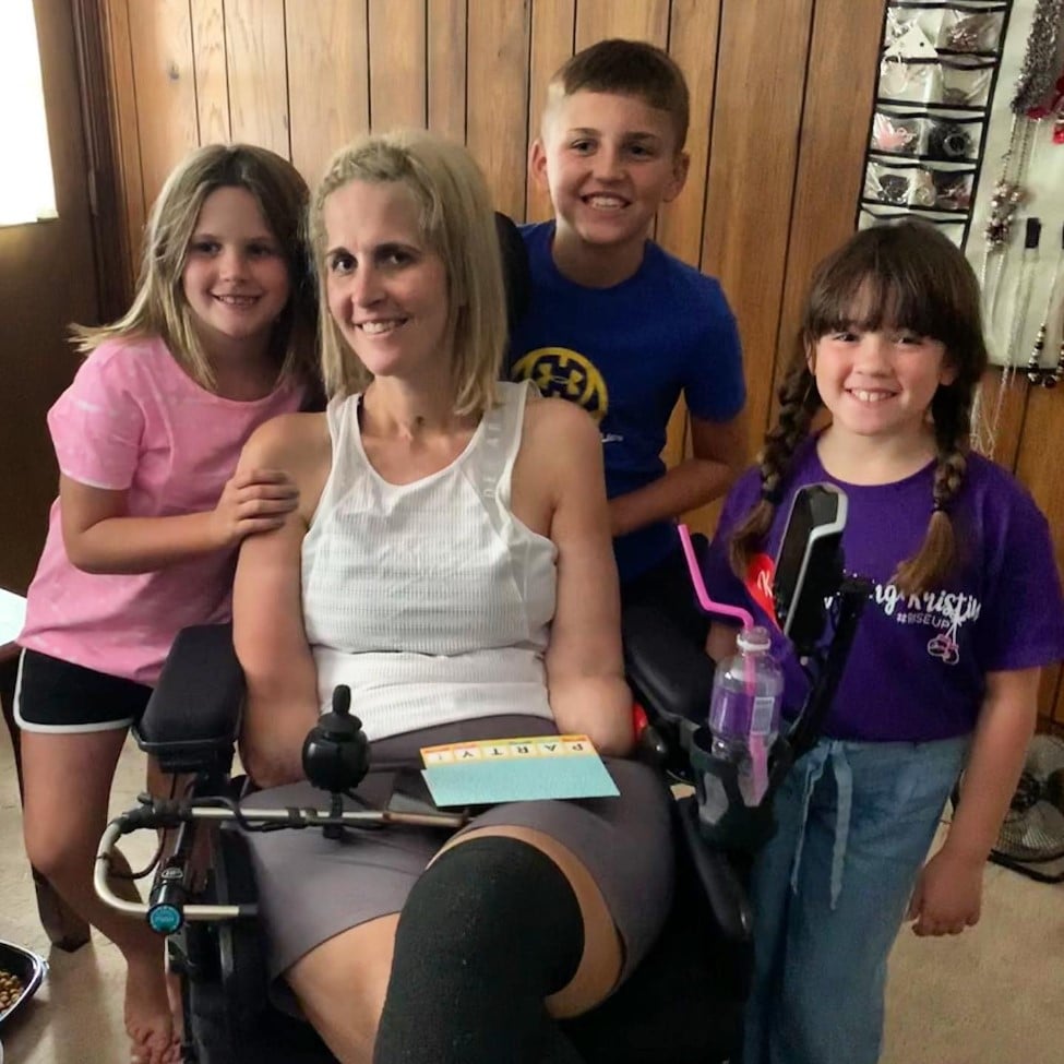 Kristin Fox in her wheelchair with her two children and friend