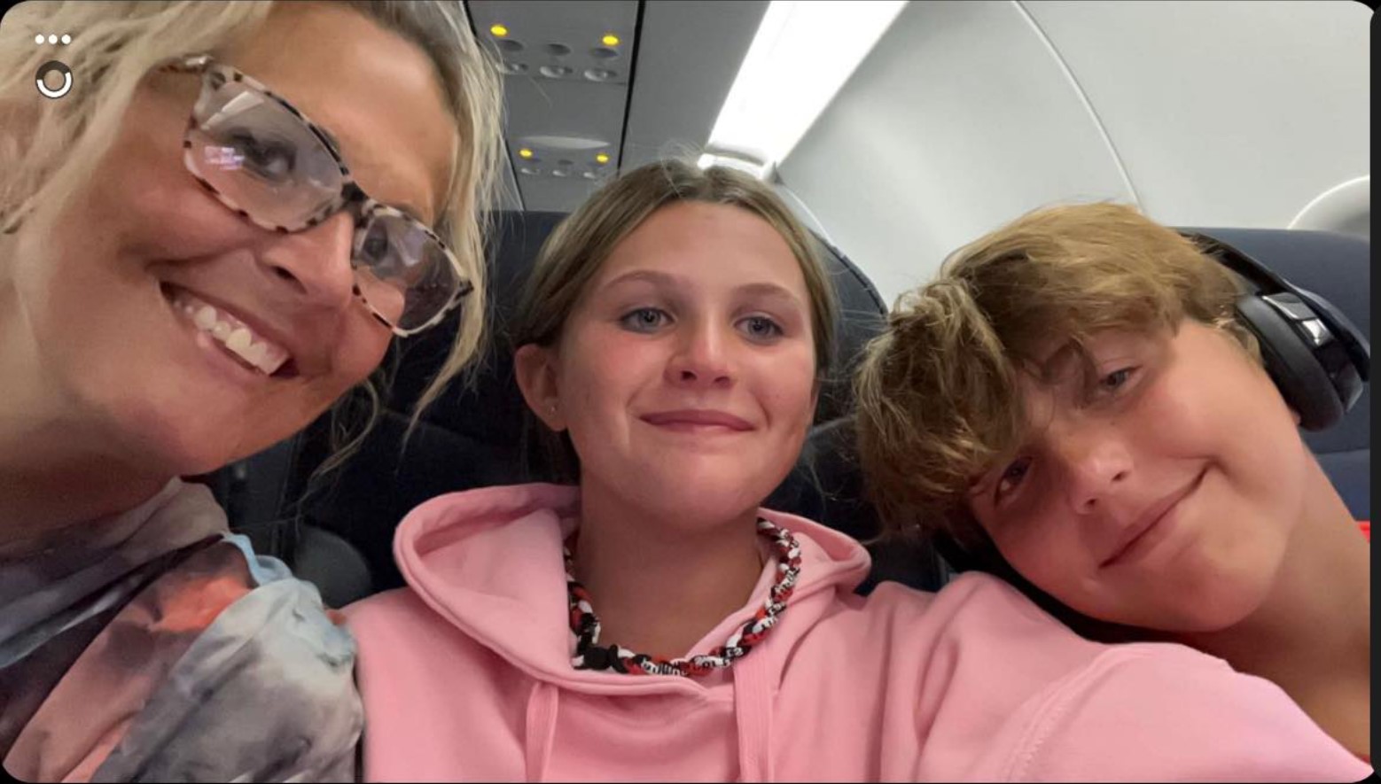 Kristin Fox and her two children take a selfie on a plane