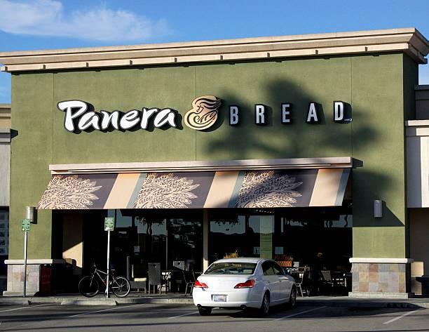An image of a white car park outside Panera Bread’s storefront